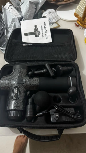 Massage gun in a black case with accessories on a table
