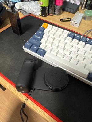 Keyboard and mouse on a desk with various items in the background