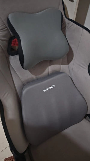 Gray pillow with 'awesome' branding on a beige chair.