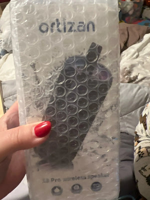 Ortizan product packaging with a speaker inside, held by a hand.