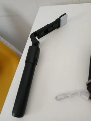 Black smartphone holder on a white surface with a cable.