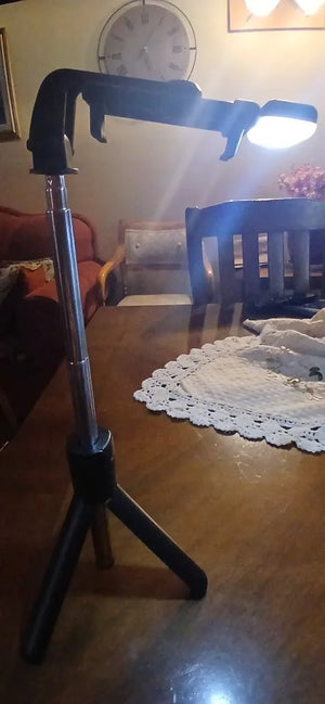 Black selfie stick on a wooden table with a blurred background