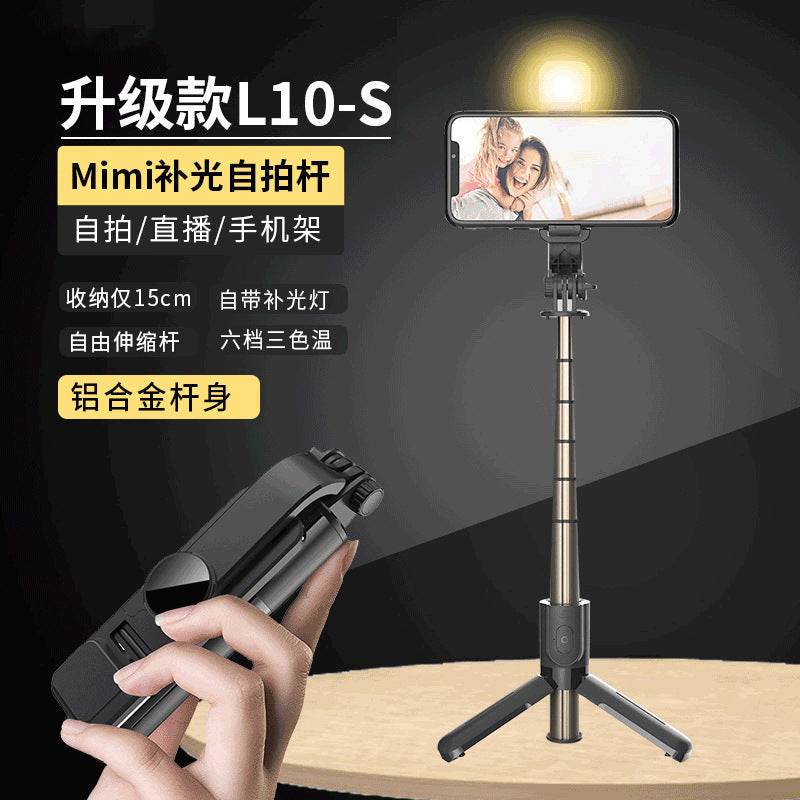 Hand holding a smartphone with a selfie stick and light on a black background
