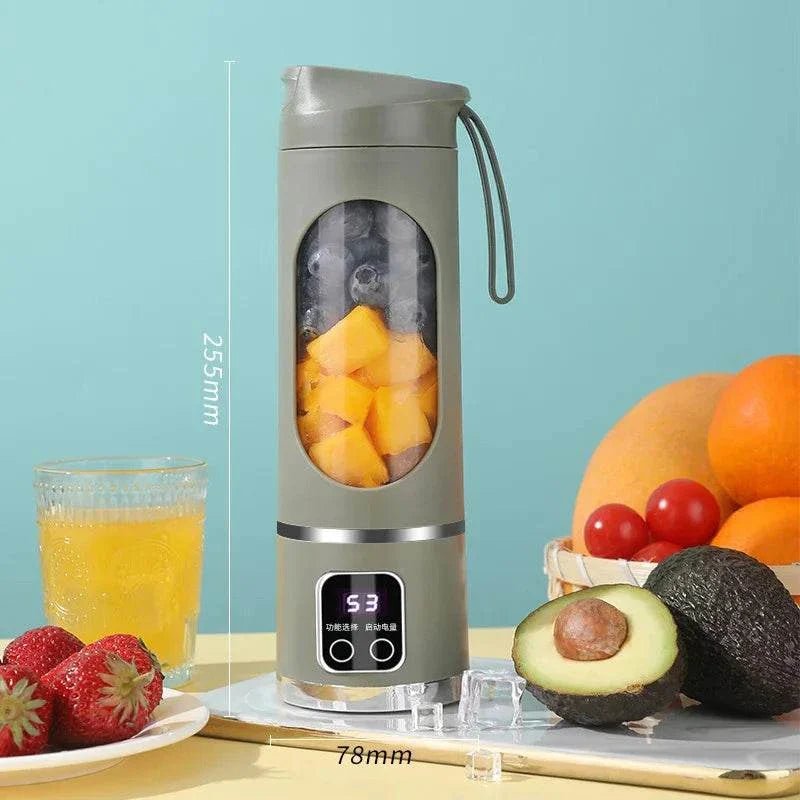 Portable blender with fruits and a glass of juice on a light blue background