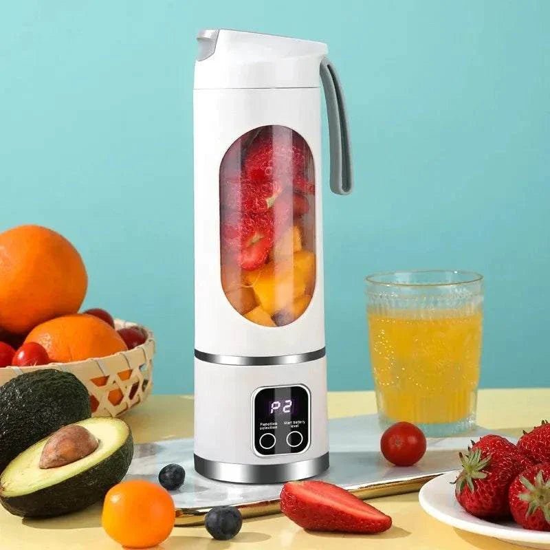Portable blender with fruits and a glass of juice on a table