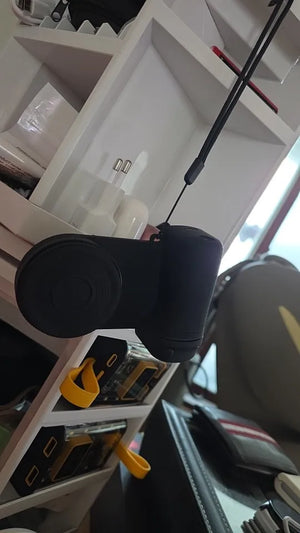 Black camera lens on a white shelf with tools and items in the background
