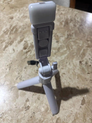 Small gray tripod on a beige surface