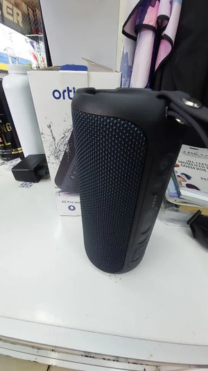 Black textured object on a white surface with various items in the background