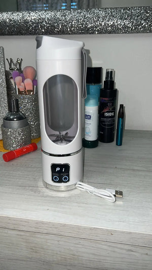 White electronic device with display and buttons on a surface with grooming products in the background.