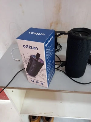 ortizan speaker and its packaging on a surface with a white background