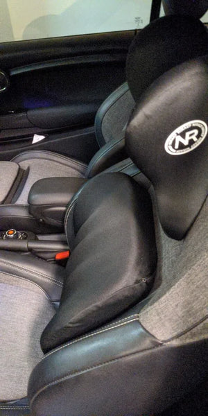 Car interior with black seats featuring a logo, close-up view.