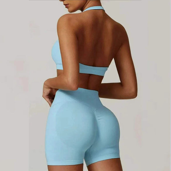 Person wearing a light blue sports bra and shorts set on a plain background
