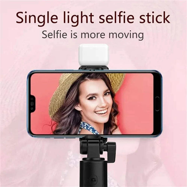 Single light selfie stick with smartphone on pink background