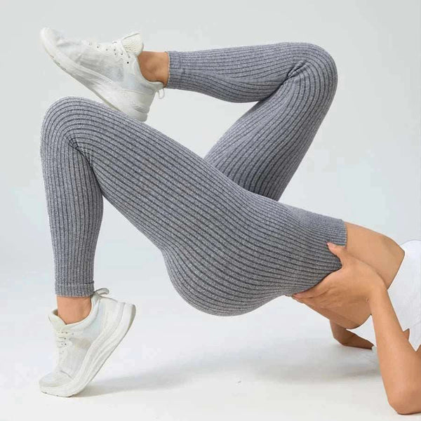 Person wearing gray ribbed knit pants and white sneakers on a light gray background